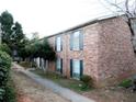 Exterior angle shot of apartment complex featuring brick facade, green shutters, and walkway at 5586 Kingsport Dr, Atlanta, GA 30342