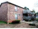 Exterior shot of building showcasing brick facade and wood decks with stairs leading to units at 5586 Kingsport Dr, Atlanta, GA 30342