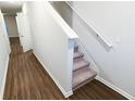 A staircase with carpet steps and white painted handrail at 8666 Webb Rd, Riverdale, GA 30274