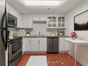Efficient kitchen with stainless steel appliances, white cabinets, and uniquely patterned terracotta tile flooring at 2870 Pharr Court South Nw # 2901, Atlanta, GA 30305