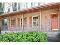 Inviting brick front porch with columns, railings, large windows, and attractive orange front door at 3969 Briaridge Cir, Atlanta, GA 30340