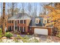 Beautiful brick home featuring an attached garage, black shutters and autumn foliage at 355 Highlands Trce, Roswell, GA 30075