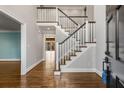 Bright foyer featuring hardwood floors, a staircase with white banisters, and access to other rooms at 355 Highlands Trce, Roswell, GA 30075