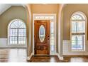 Elegant foyer with hardwood floors showcases a beautiful front door flanked by arched windows and classic trim at 384 Minix Rd, Sharpsburg, GA 30277