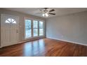 Bright living room with hardwood floors, large windows, and ceiling fan at 1098 Laurel Nw Ln, Conyers, GA 30012