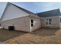 Rear exterior view of brick home featuring a well-maintained lawn at 815 Crossroads Ct, Social Circle, GA 30025