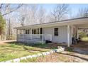 Charming single-story home with a covered porch, carport, and landscaped front yard featuring rock-lined flowerbeds at 3642 Highway 81, Oxford, GA 30054