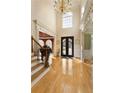 Bright foyer with hardwood floors, staircase, a chandelier, and elegant architectural details at 1163 Ascott Valley Dr, Johns Creek, GA 30097