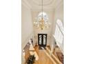 A high angle view of the foyer showcases a chandelier and hardwood floors at 1163 Ascott Valley Dr, Johns Creek, GA 30097