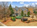 Stunning two-story brick home with a beautifully landscaped front yard featuring a variety of lush plants and trees at 2310 Gracehaven Way, Lawrenceville, GA 30043