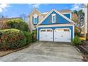 Charming home with a blue exterior, white trim, and a two-car garage, complemented by a well-manicured lawn at 240 Leasingworth Way, Roswell, GA 30075