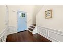 Inviting foyer with dark wood floors, a staircase, fresh paint, and a decorative wainscoting, creating a welcoming entrance at 240 Leasingworth Way, Roswell, GA 30075