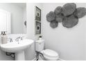 Elegant half bathroom with a modern sink, stylish mirror, and decorative wall art at 341 Skylar Se Way, Atlanta, GA 30315