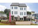Charming three-story townhome with white siding and brick accents, complemented by lush landscaping at 341 Skylar Se Way, Atlanta, GA 30315