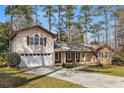 Traditional home boasts an attached garage, long driveway, and lush landscaping for serene suburban living at 2542 Maclaren Cir, Dunwoody, GA 30360