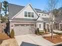Attractive house with gray siding, brick accents, a two-car garage, and a neatly landscaped yard at 105 Ivey Way, Woodstock, GA 30188