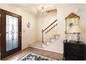 Inviting entryway features a glass paneled door, wood floors, and a staircase with carpet runner at 5443 Dunwoody Knoll Ct, Dunwoody, GA 30338