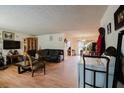 Open-concept living room with laminate floors and dining area, bathed in natural light at 5461 Chuzzlewit Sw Ct, Lilburn, GA 30047