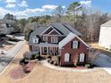 Charming two-story brick home featuring an inviting entrance and manicured front yard with shrubs at 3000 Shade Tree Ct, Villa Rica, GA 30180