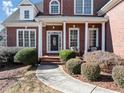 Inviting front porch with white columns, seating and manicured shrubs create beautiful curb appeal at 3000 Shade Tree Ct, Villa Rica, GA 30180