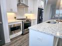 Modern kitchen with white cabinetry, stainless steel appliances, and granite countertops at 3255 Bartee Walk, Suwanee, GA 30024