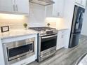 Modern kitchen featuring stainless steel appliances, white subway tiles, and ample cabinet space at 3255 Bartee Walk, Suwanee, GA 30024