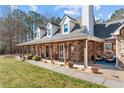 Inviting front porch featuring stone accents, seating, and decorative details for a cozy entrance at 212 Lakeview Dr, Newborn, GA 30056