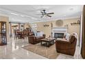 Spacious living room with a fireplace, leather sofas, a ceiling fan, and an open dining area at 212 Lakeview Dr, Newborn, GA 30056