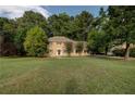 Traditional two-story home with mature trees sits on a spacious green lawn at 1261 William Robert Sw Dr, Marietta, GA 30008