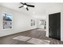 Bright living room featuring dark hardwood floors and a modern ceiling fan, complemented by large windows at 1106A Wedgewood Nw Dr, Atlanta, GA 30318