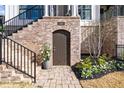 Close-up of a home's brick foundation, arched basement entrance, and professionally landscaped beds at 1311 English Nw St, Atlanta, GA 30318