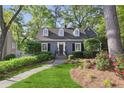 Charming two-story home featuring lush landscaping and a welcoming walkway leading to the front entrance at 560 Collier Nw Rd, Atlanta, GA 30318