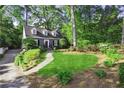 Charming two-story home featuring lush landscaping and a welcoming walkway leading to the front entrance at 560 Collier Nw Rd, Atlanta, GA 30318