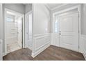 Bright foyer featuring hardwood floors, a white door with sidelight, and trim detailing at 144 Laurel Farms Ln, Dallas, GA 30157