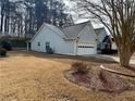 A view of the side of the house, with a two car garage and a well manicured lawn at 1854 Brittlebank Ln, Lawrenceville, GA 30043