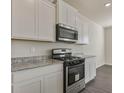 Galley kitchen features granite countertops, stainless steel oven, and white cabinets at 206 Oak View Ln, Dallas, GA 30157