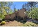 Charming two-story home with a lush green lawn, mature trees, and a private driveway at 2235 Six Branches Dr, Roswell, GA 30076