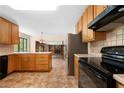 Well-lit kitchen with plenty of wood cabinet space and a black electric range at 2235 Six Branches Dr, Roswell, GA 30076