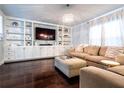 Cozy living room featuring custom built-ins, a modern chandelier, and large windows for natural light at 1005 Brighton Pt, Atlanta, GA 30328