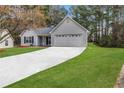 Single-story home with light gray siding, black shutters, lush green lawn and a wide driveway at 637 Delay Way, Stockbridge, GA 30281