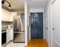 Functional entryway with coat closet, black door, stainless fridge, and white cabinets at 3655 Habersham Ne Rd # 344, Atlanta, GA 30305