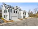 Modern townhomes showcasing a mix of white brick and siding, with attached garages at 2150 Tidwell Ln # 5, Atlanta, GA 30318