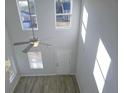 Bright living room featuring tall windows, hardwood floors, and a modern ceiling fan, creating a welcoming atmosphere at 75 Heyman, Covington, GA 30016