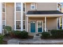 Inviting condo entrance featuring double front doors, a cozy porch, and manicured shrubs for curb appeal at 6420 Magnolia Way, Morrow, GA 30260
