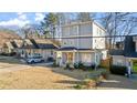 View of gray colored three-story home with a well maintained lawn and lush greenery at 1557 Alder Se Ct, Atlanta, GA 30317