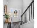 Bright foyer with a decorative mirror, dark wood floors, and staircase at 18 Village Trce, Rydal, GA 30171