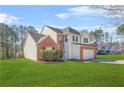 Beautiful home with a well-manicured lawn, brick accents, vinyl siding, mature trees, and an attached garage at 5300 Willow Park Blvd, Atlanta, GA 30349