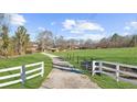 Long private driveway framed by a white fence leading to the picturesque property at 1511 Broadnax Mill Road, Loganville, GA 30052