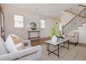 Open-concept living room with hardwood floors, neutral tones, stylish decor, and staircase at 301 Fortune St, Atlanta, GA 30312