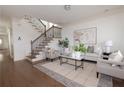 Bright living room with staircase, featuring hardwood floors, stylish furniture, and modern decor at 301 Fortune St, Atlanta, GA 30312